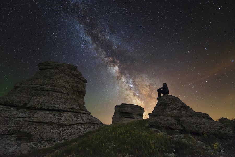 Man sits on top of Demerdzhi mountain under the Milky Way at night in Alushta, Crimea. Photograph by Yuri Zvezdny/Stocktrek Images