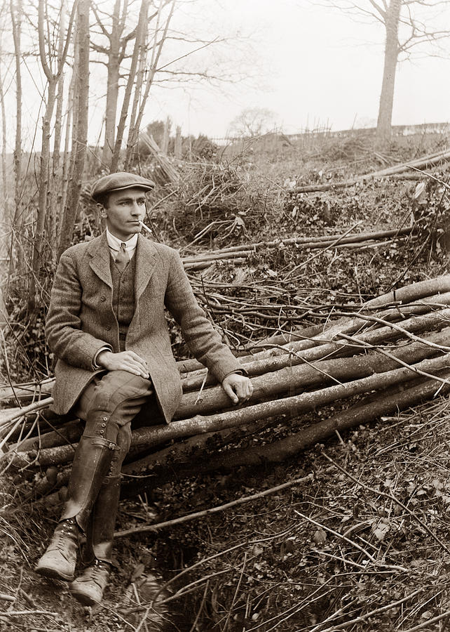 Man sitting on logs  Photograph by Photographer unknown