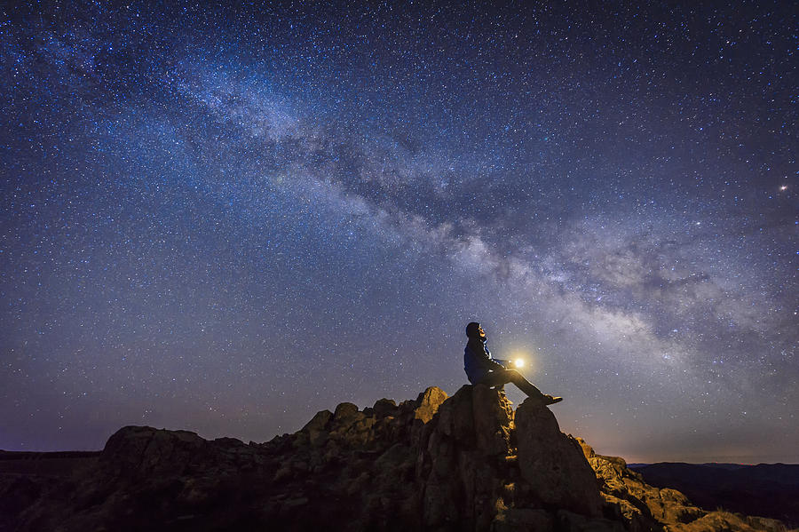 Man sitting under The Milky Way Galaxy Photograph by Bjdlzx