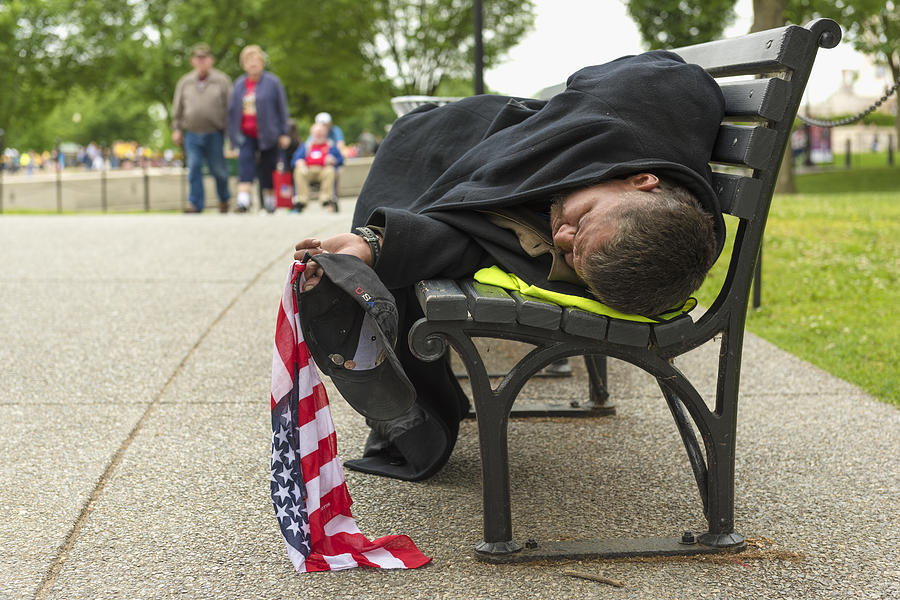 Man sleeping on a park bench in Washington DC whilst holding a Stars and Stripes flag Photograph by Sharrocks