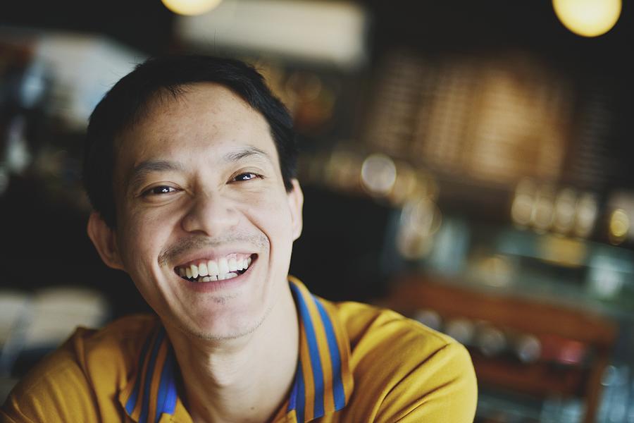 Man smiling in a cafe Photograph by Carlina Teteris