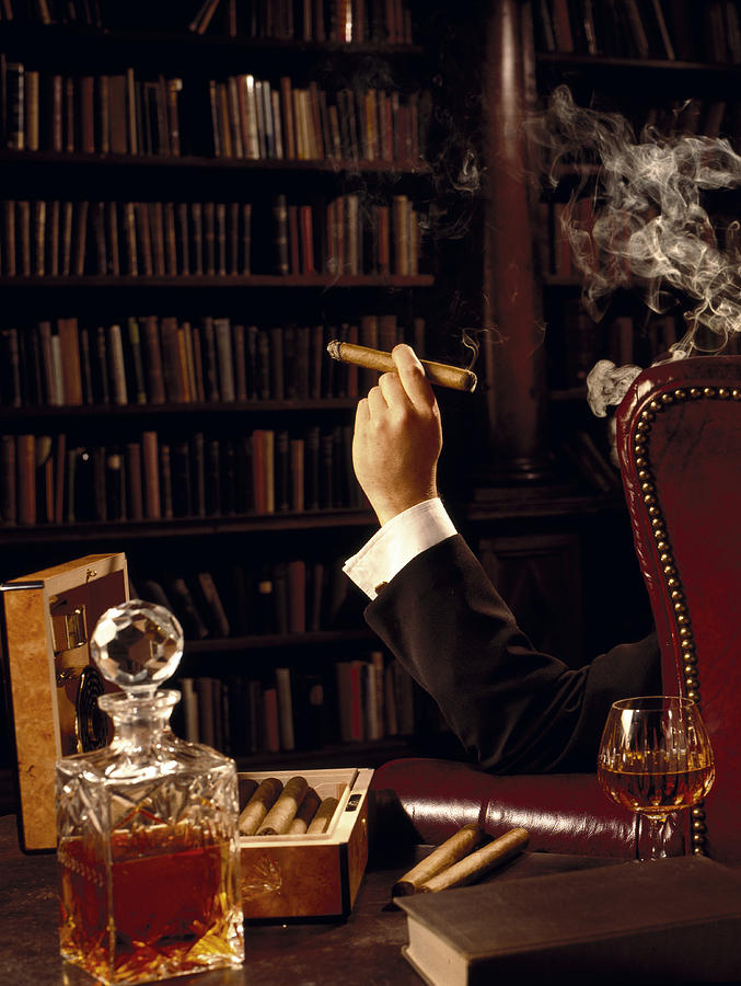 Man smoking cigar in library Photograph by Howard Berman