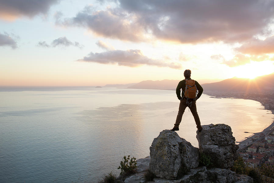 Man Stands Between Rocks Above Sea Photograph by Ascent/pks Media Inc.