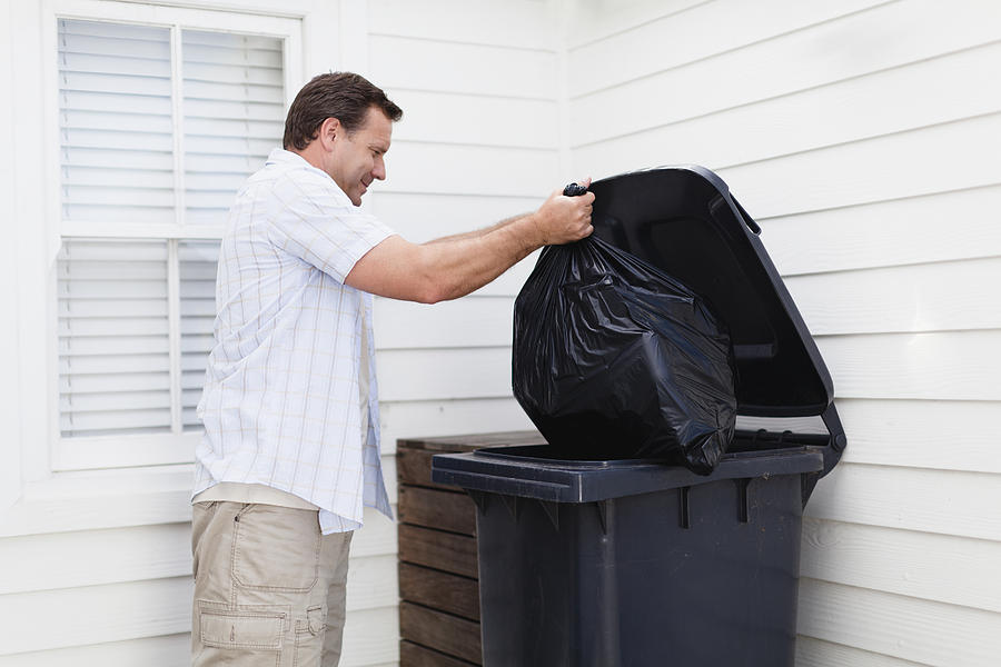 Man taking out garbage Photograph by Hybrid Images