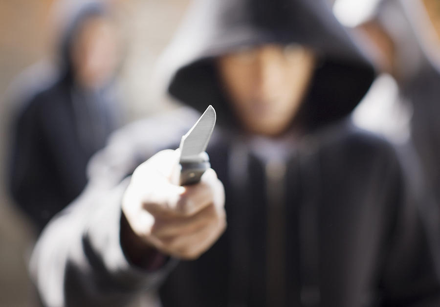 Man threatening with pocket knife Photograph by Paul Bradbury