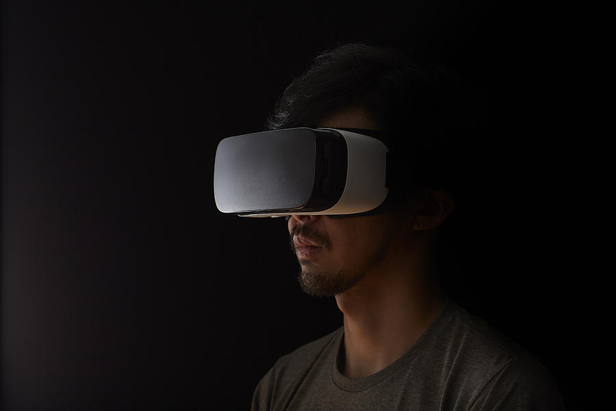 Man using a virtual reality headset Photograph by D-base