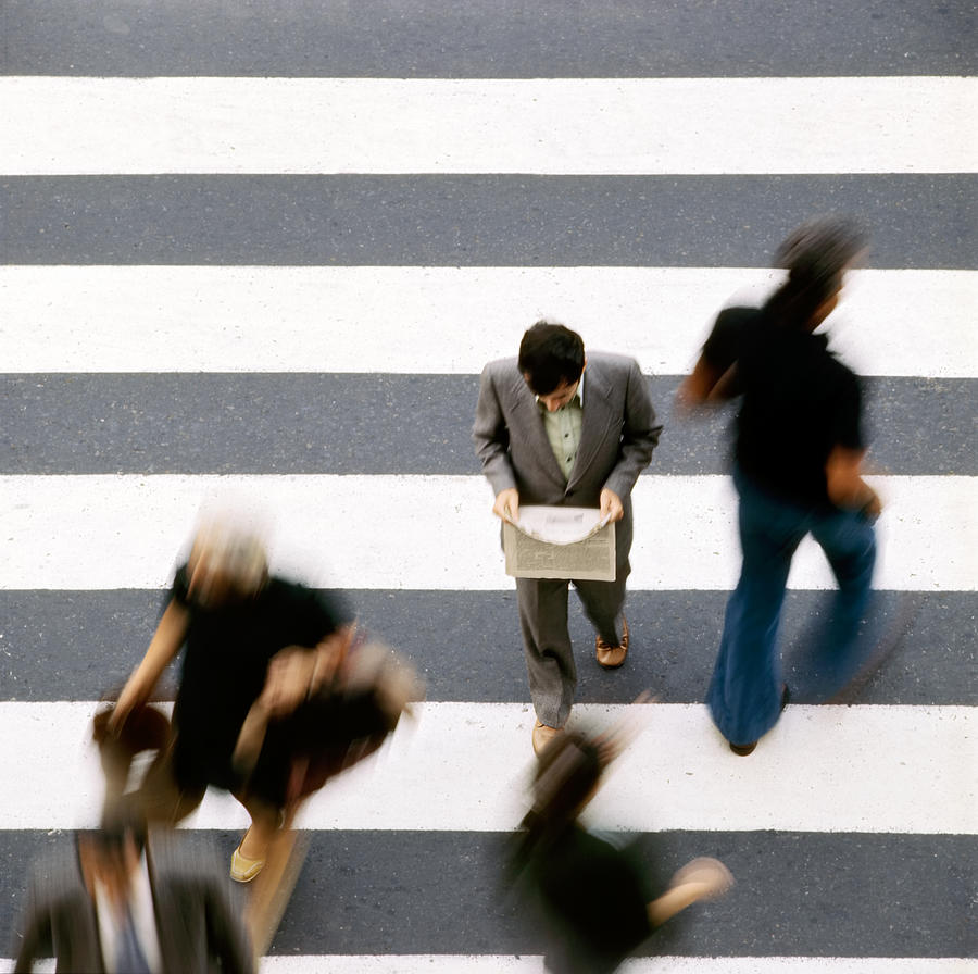 Man walking and reading newspaper on zebra crossing Photograph by Juan Carlos Ferro Duque