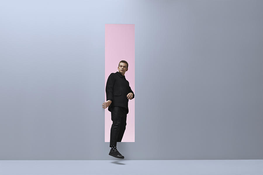 Man walking threw rectangular opening in coloured room Photograph by Klaus Vedfelt