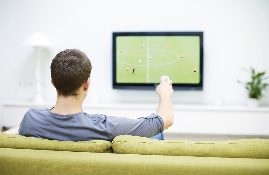 Man watching football on television               Photograph by Newton Daly