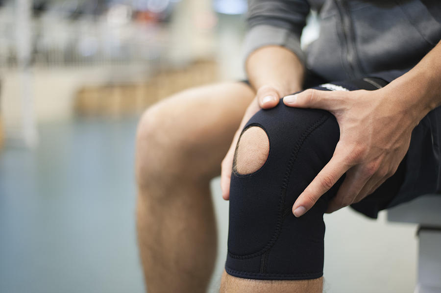 Man wearing knee brace, cropped Photograph by PhotoAlto/Odilon Dimier