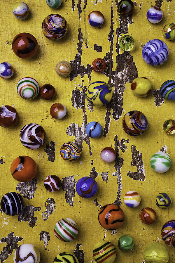 Toy Photograph - Marbles On Yellow Wooden Table by Garry Gay