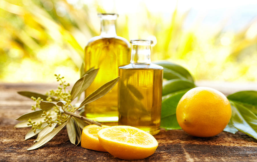 Massage oil bottles with lemons and olive branch Photograph by GSPictures