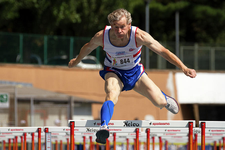 Masters British Athlete Clearing Hurdle Photograph by Alex Rotas