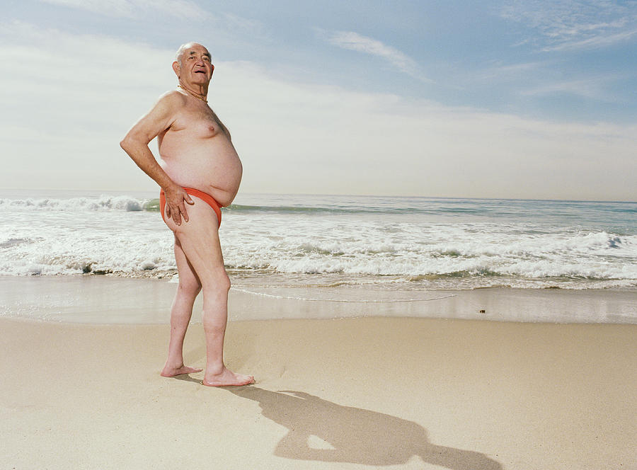 Mature man wearing swimsuit on beach Photograph by Sean Murphy