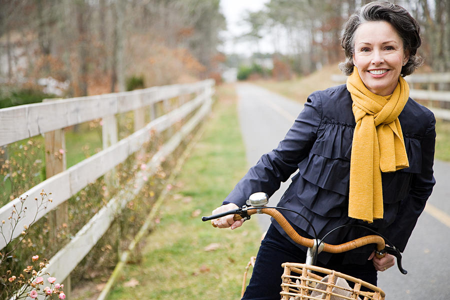 Mature woman on a bicycle Photograph by Image Source
