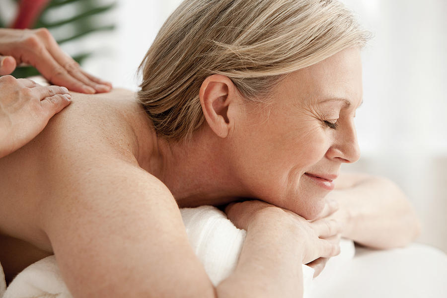 Mature woman receiving massage Photograph by Image Source