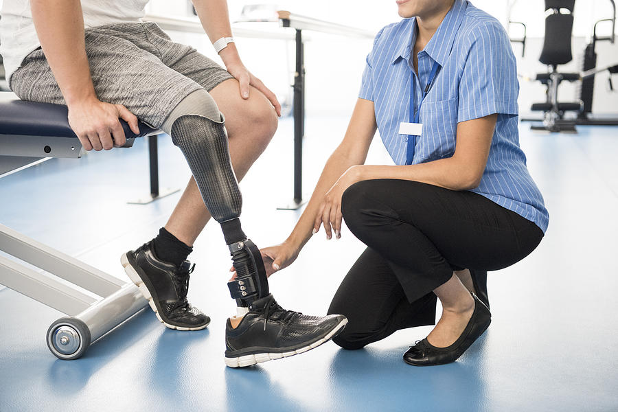 Medical professional helping man with prosthetic leg Photograph by JohnnyGreig