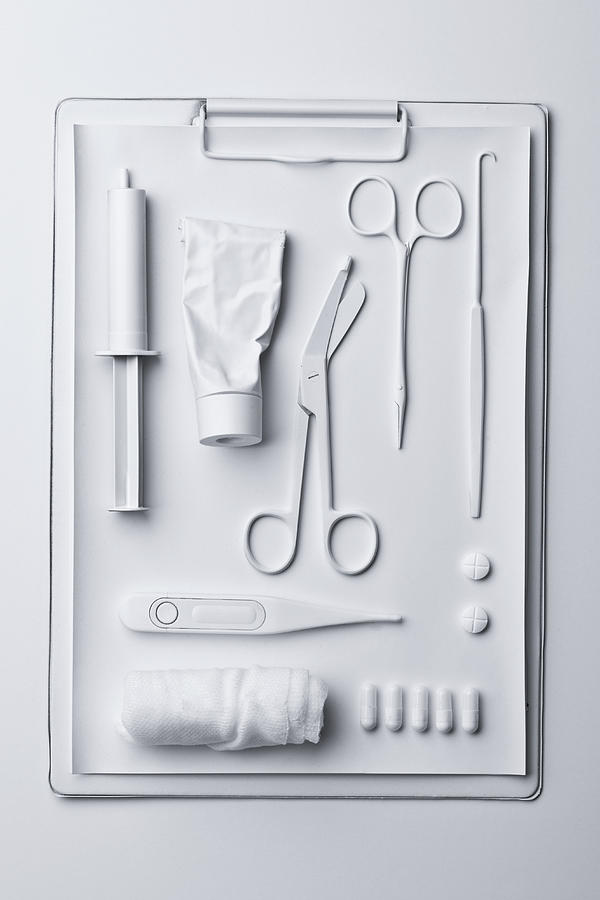 Medicine and medical equipment painted white and laid out on a clipboard Photograph by Larry Washburn