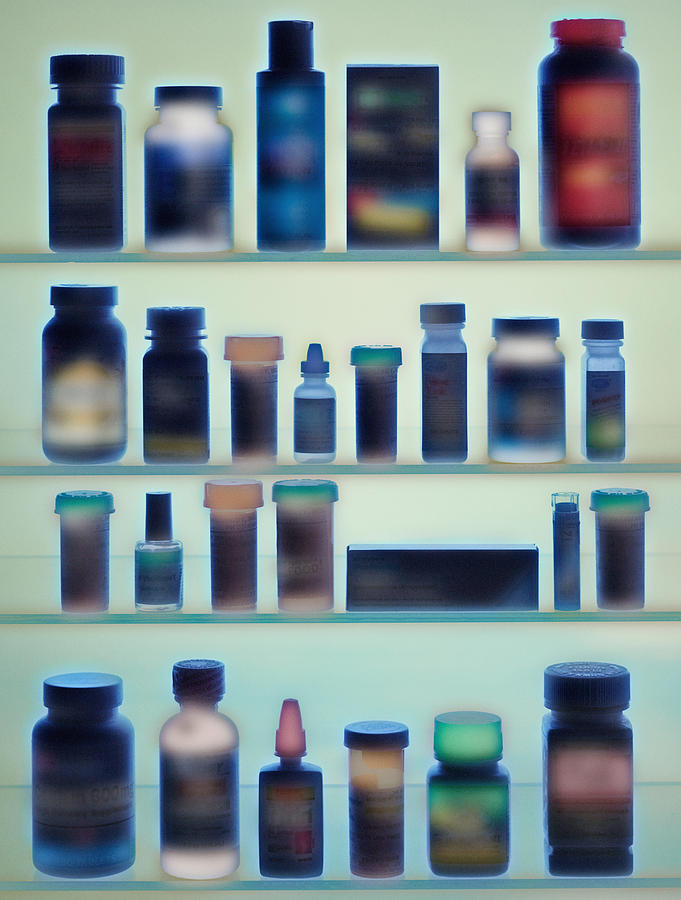 Medicine bottles in cabinet Photograph by Image Source