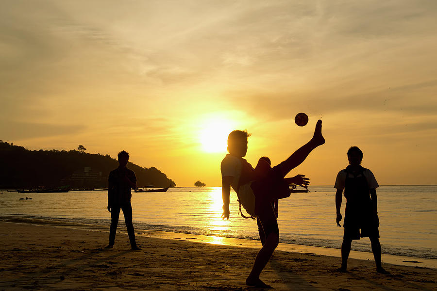 Men Playing Takraw Ball At Sunset On Photograph by Stuart Corlett / Design Pics