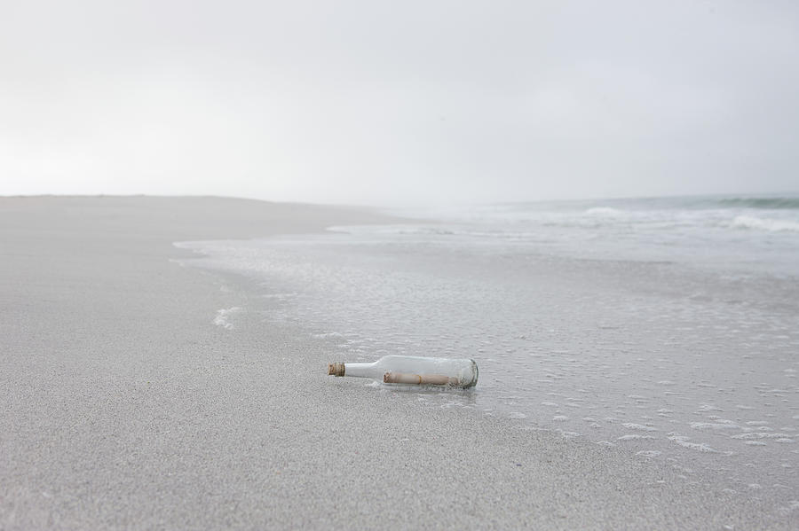 Message In Bottle Washed Up On Beach Photograph by Zero Creatives