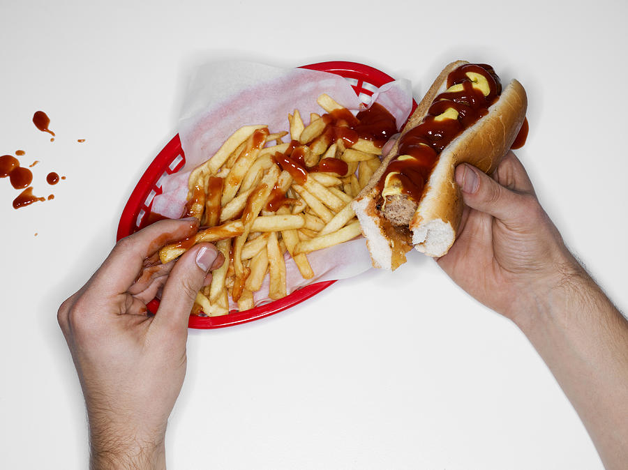 Messy eating, hot dog and fries, overhead view Photograph by Jonathan Knowles