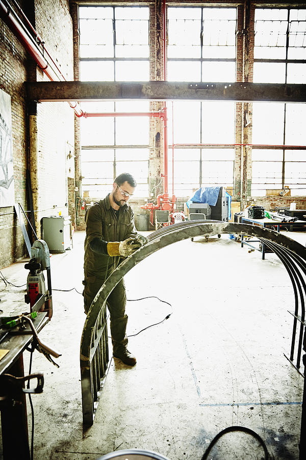 Metal worker using angle grinder to polish project Photograph by Thomas Barwick