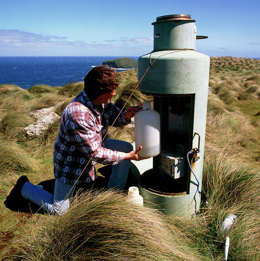Instruments Photograph - Meteorologist Examines A Rainfall Monitor by Cape Grim B.a.p.s./simon Fraser/science Photo Library