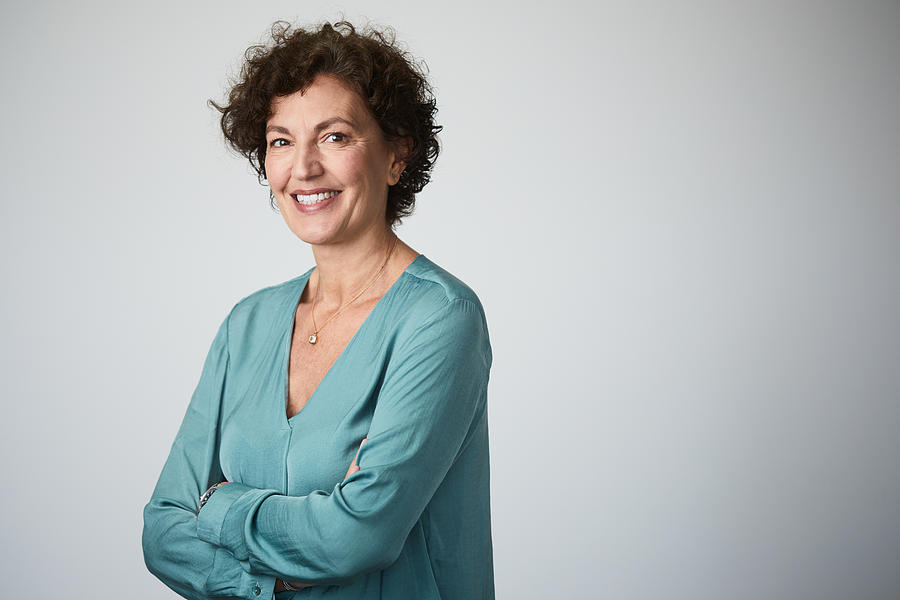 Mid adult businesswoman headshot on grey background. Photograph by Tempura Mid adult businesswoman headshot on grey background. Photograph by Tempura