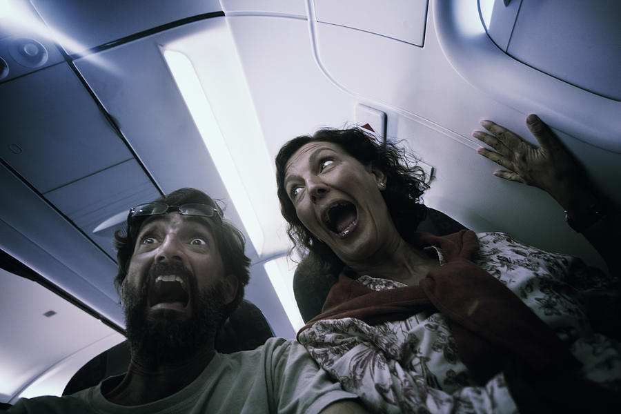 Middle aged couple in terror on a plane. Photograph by Tempura