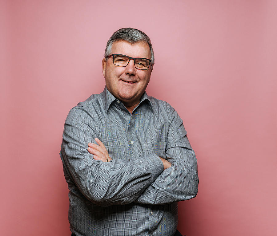 Middle-aged man with glasses on pink background Photograph by Ian Ross Pettigrew