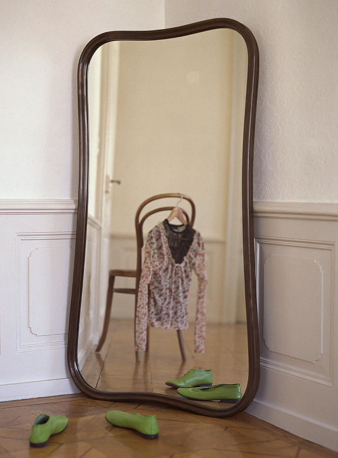 Mirror reflecting chair with blouse hanging from it. Photograph by Matthieu Spohn