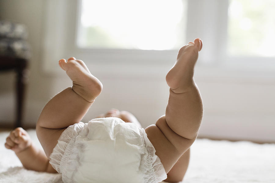 Mixed race baby girl laying on floor Photograph by Roberto Westbrook
