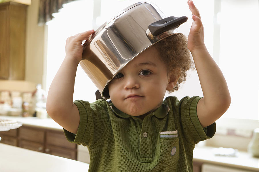 Mixed race boy with pot on his head Photograph by Jose Luis Pelaez Inc
