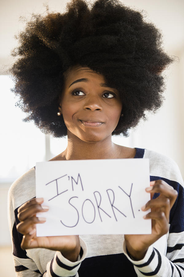 Mixed race woman holding Im sorry sign Photograph by JGI/Jamie Grill