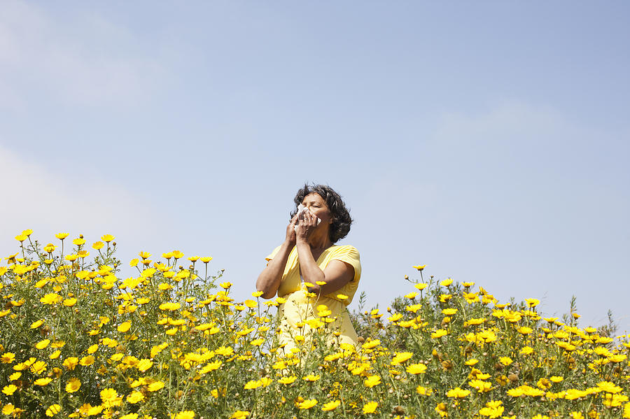 Mixed race woman in field of flowers enjoying scent Photograph by Sarah Fix