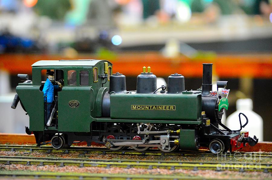 Model train green steam engine with driver in cab Photograph by Imran Ahmed
