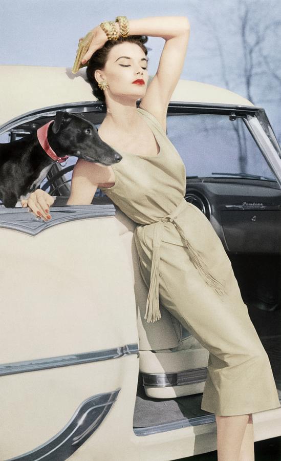 Model Wearing A Kidskin Dress Leaning On A Car Photograph by Richard Rutledge