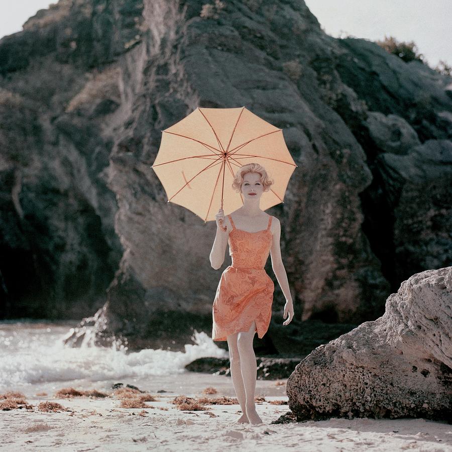 Model Wearing An Orange Bathing Suit Holding Photograph by Jerry Schatzberg