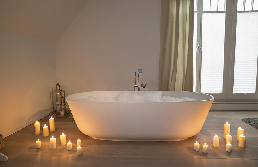 Modern bathtub with lighted candles arround Photograph by Westend61