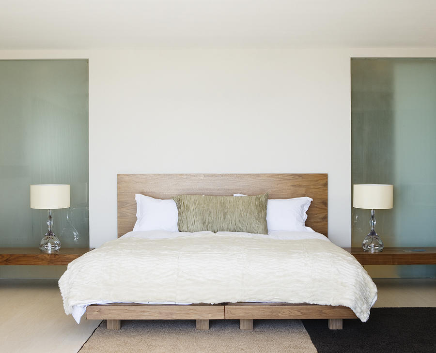 Modern double bed with bedside tables Photograph by Martin Barraud