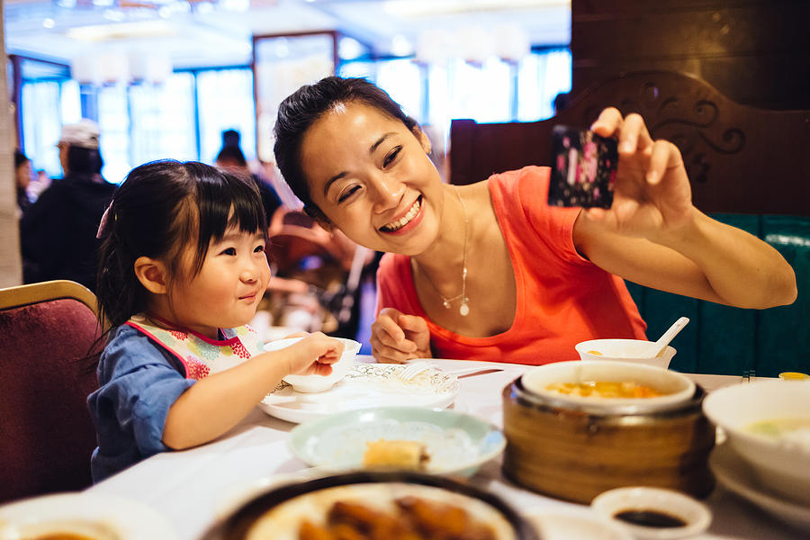Mom & toddler taking selfie in Chinese restaurant Photograph by images by Tang Ming Tung