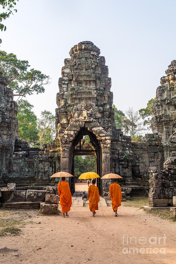 Monks with umbrella walking into Angkor Wat temple - Cambodia Photograph by Matteo Colombo