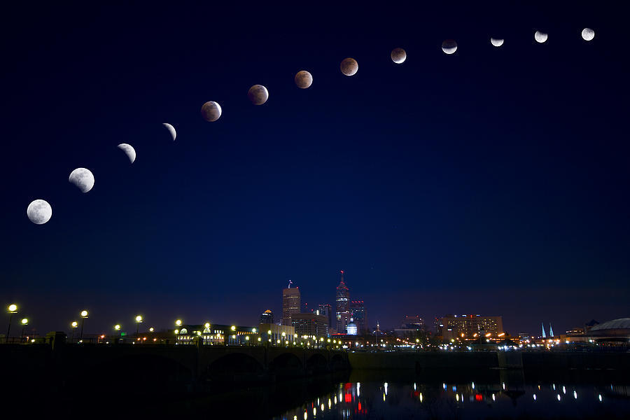 Moon eclipse over city Photograph by Alexey Stiop