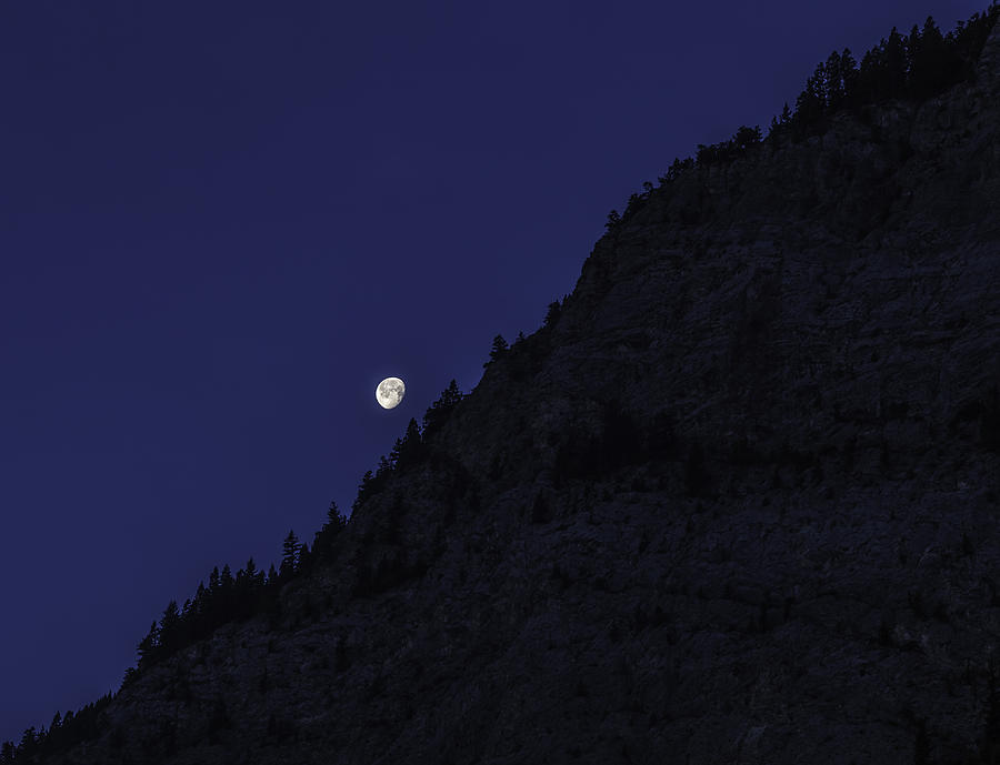 Moon Setting Behind The Rockies Photograph by Thomas Young
