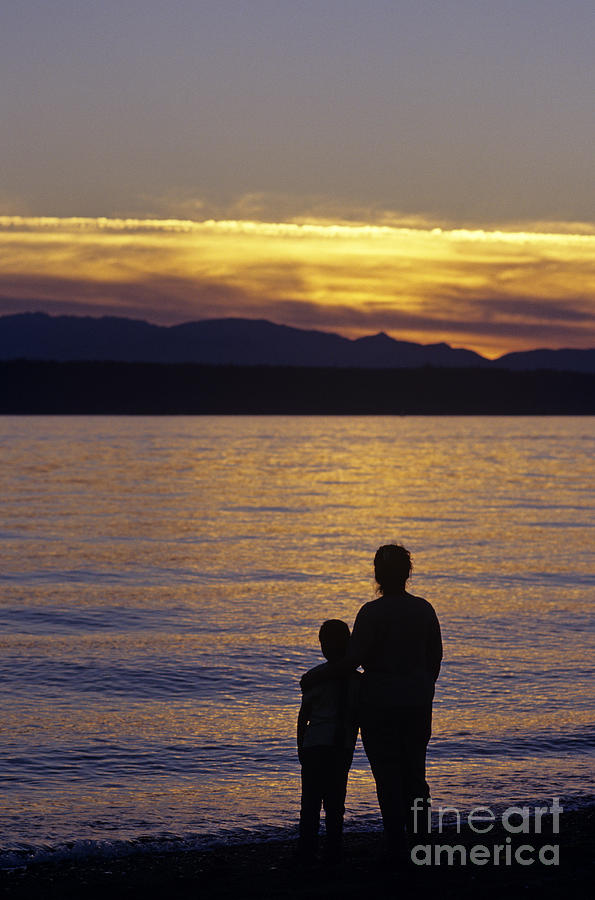 Mother and daughter holding each other along Edmonds Beach at su Photograph by Jim Corwin