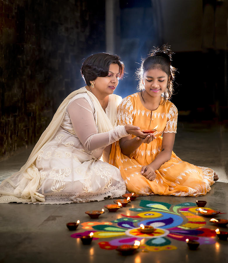 Mother and Daughter making Rangoli, decorating with Diyas for Diwali Photograph by SoumenNath