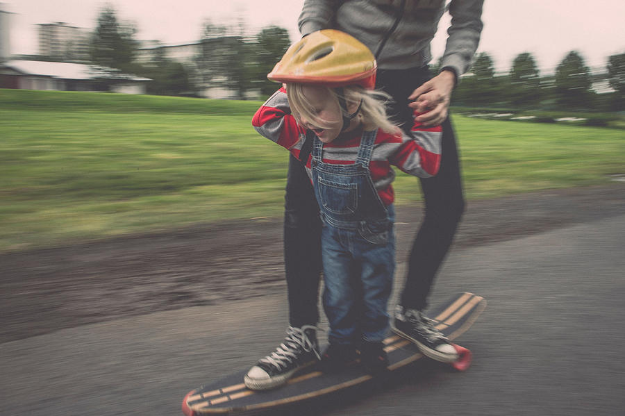 Mother and daughter riding on skateboard in park Photograph by Elli Thor Magnusson