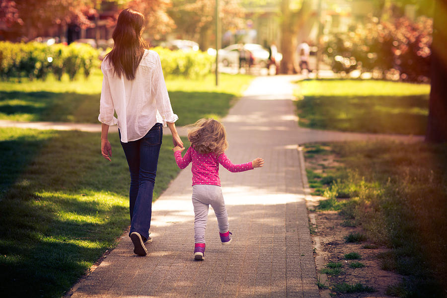 Mother And Daughter Taking A Walk In The Park Photograph by BenAkiba