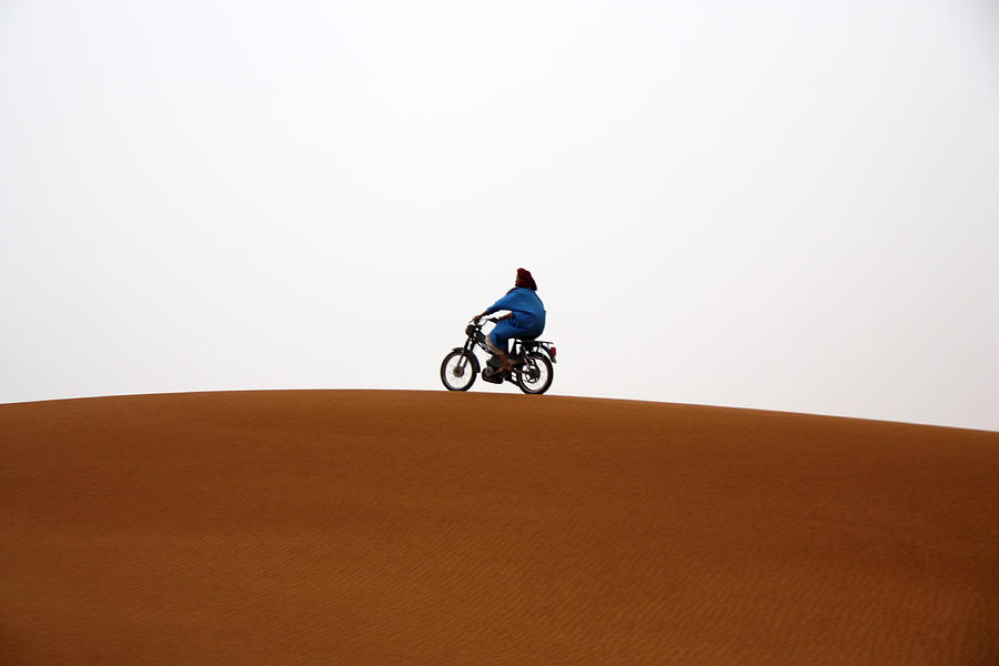 Motorbike running on desert dune Photograph by David Oliete
